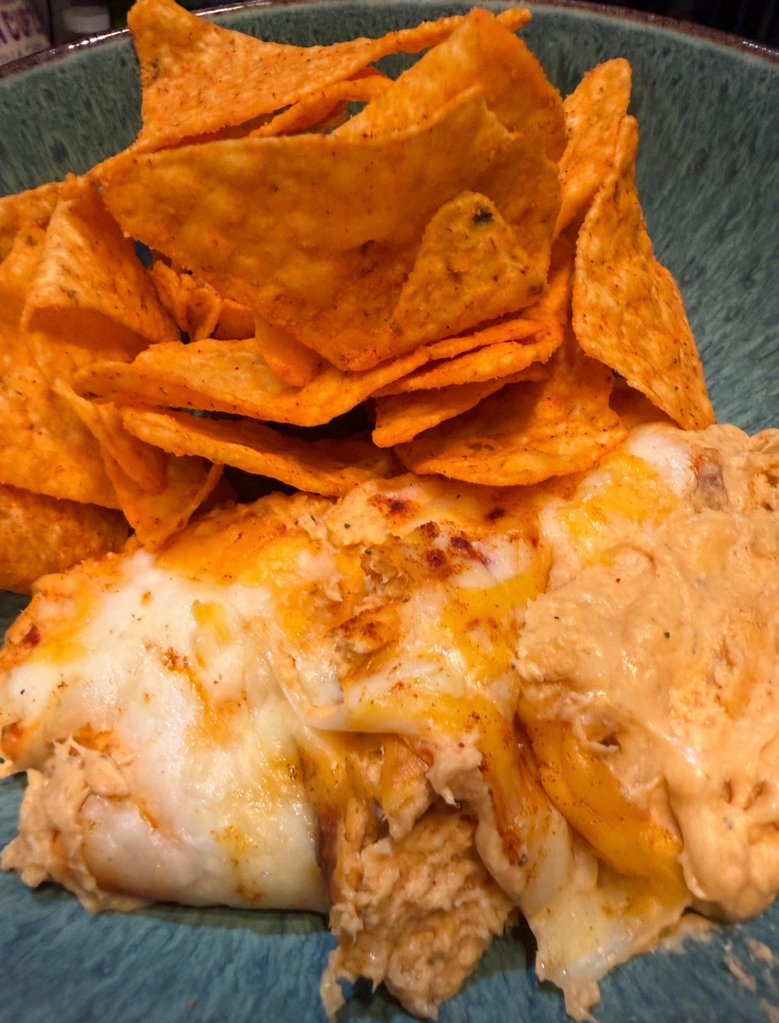 Buffalo chicken cheese dip with tortilla chips on a blue plate